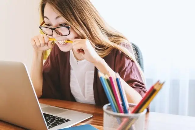 woman biting pencils