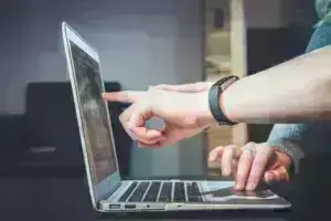 finger pointing to a laptop screen