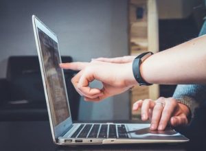 finger pointing to a laptop screen